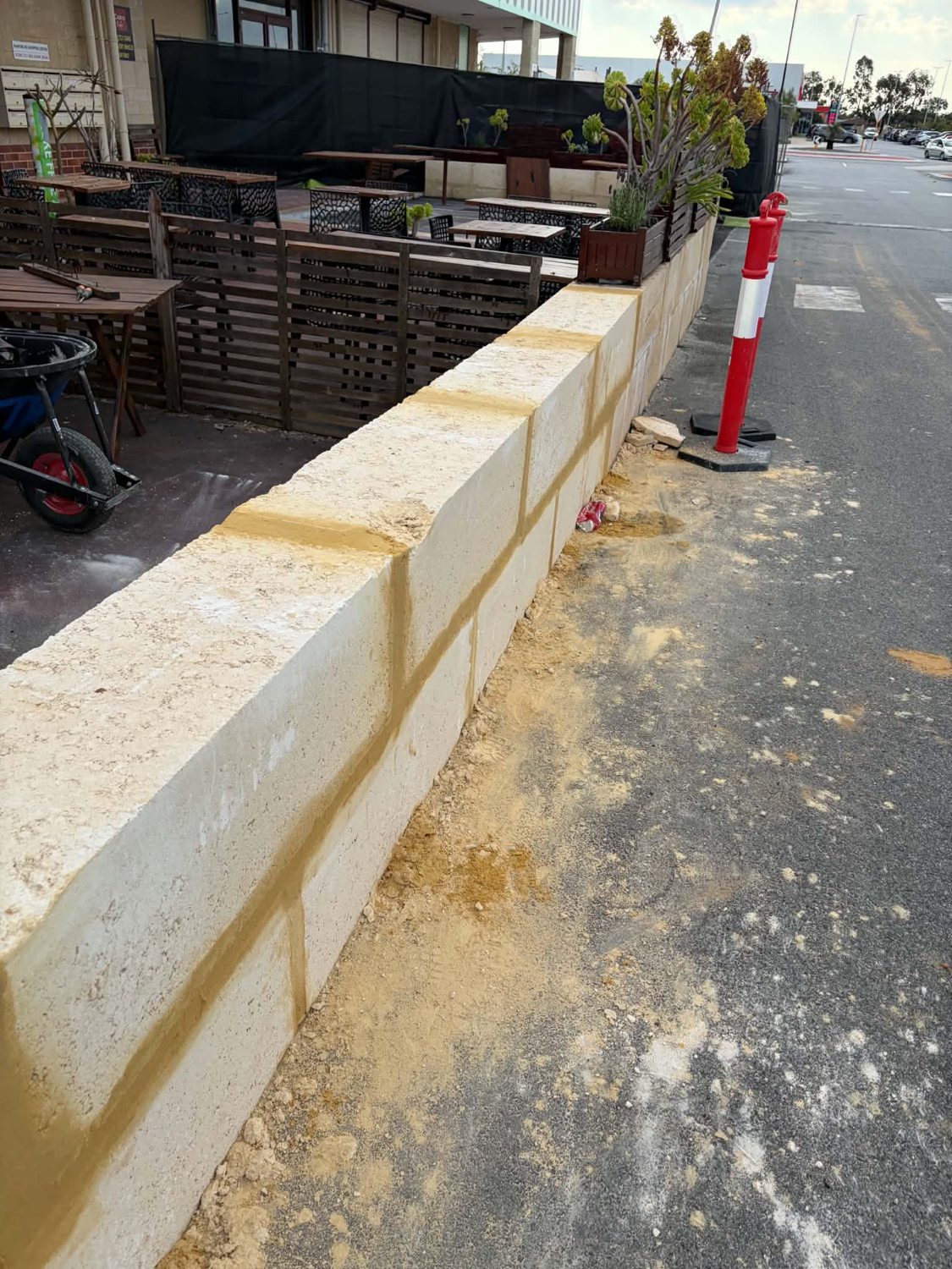 Finished limestone retaining wall section with fresh mortar joints in Perth